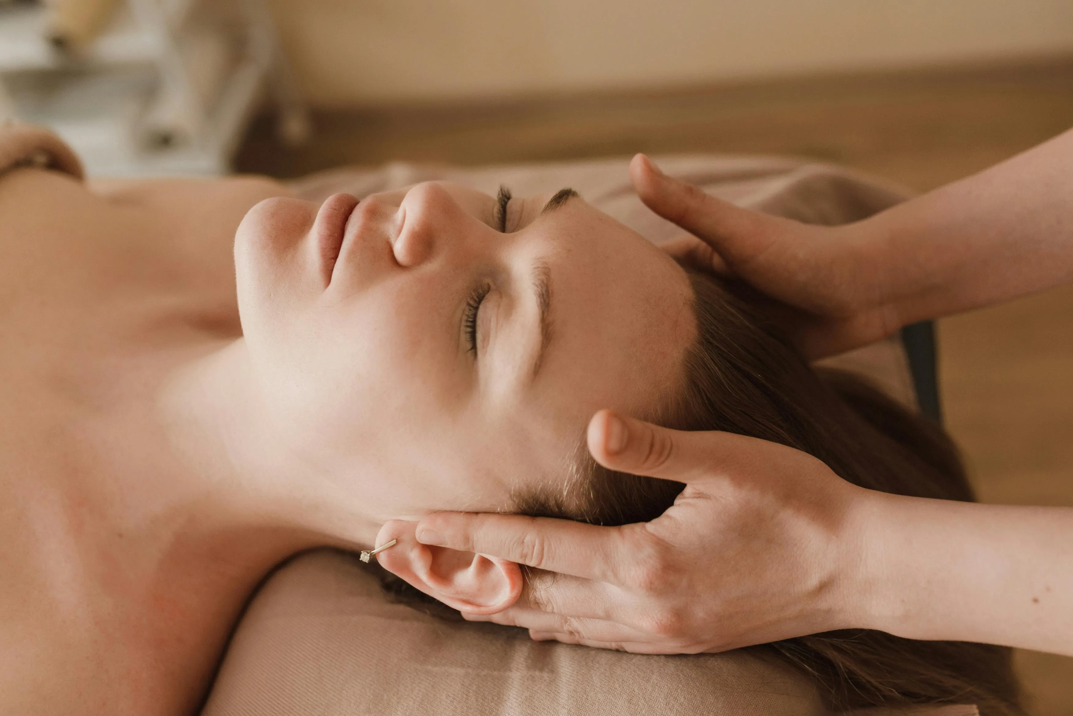 A woman getting a facial massage on her face.