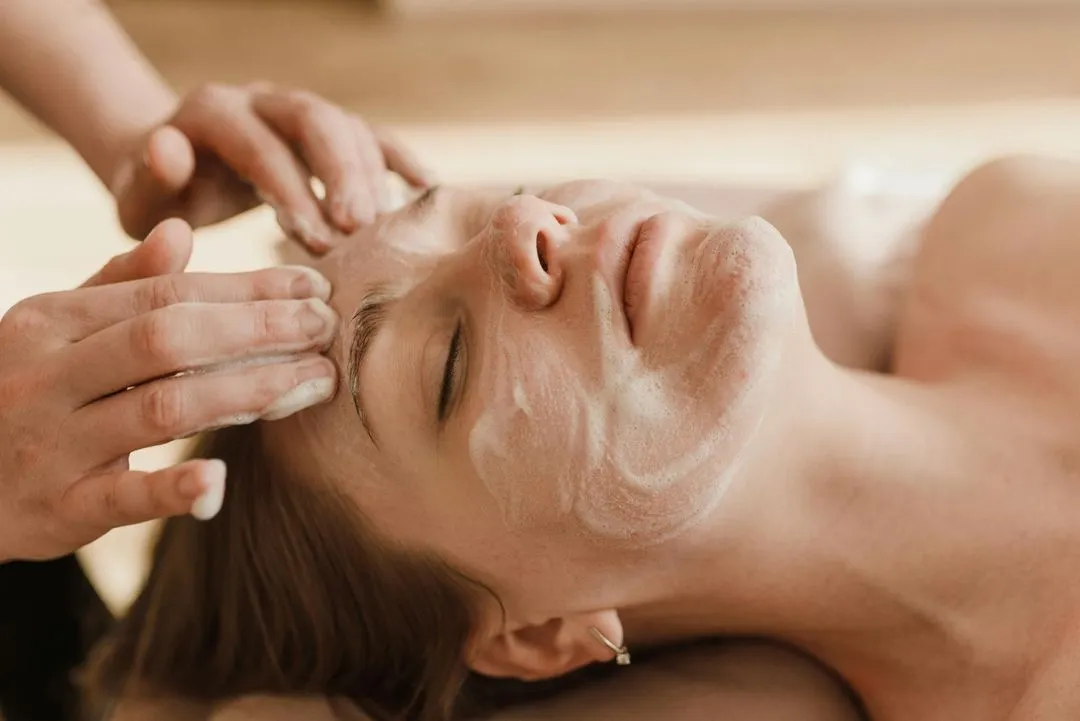 A woman getting a facial mask on her face.